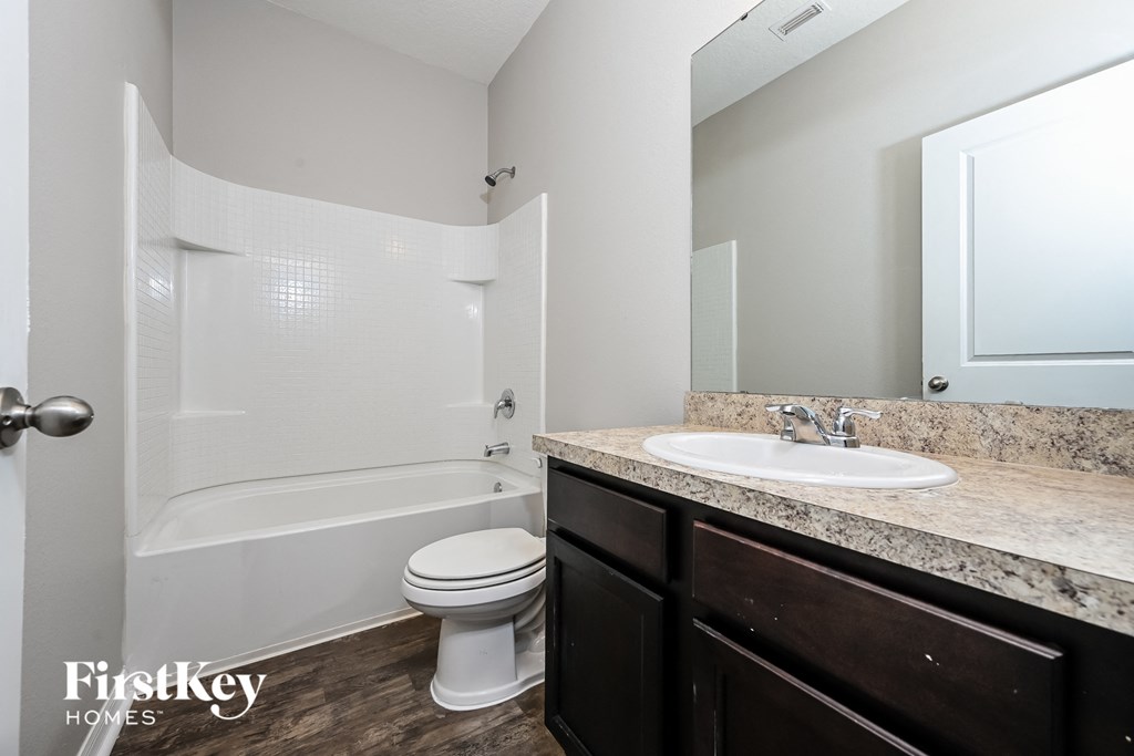 a bathroom with a sink toilet and bath tub