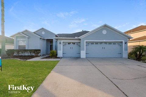 a blue house with a garage and a driveway