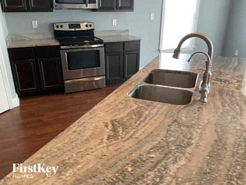A kitchen with a sink and a stove top oven.
