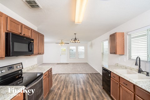a kitchen and living room with wood flooring and black appliances