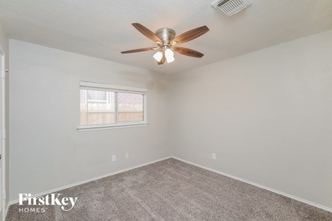 the living room has a ceiling fan and a carpet