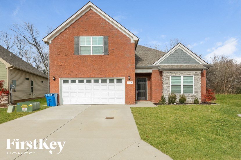A brick house with a garage door and a driveway.
