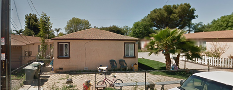 a small house with two chairs in the yard