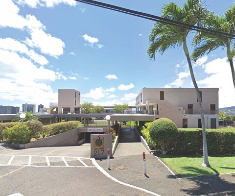 a building with a parking lot and palm trees