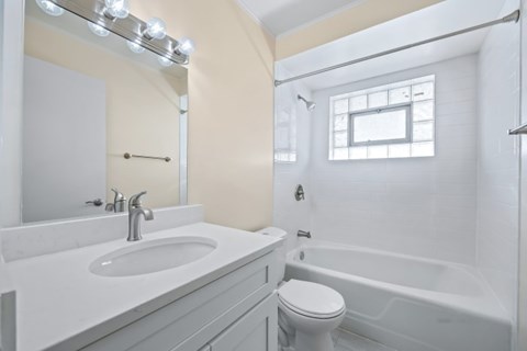 A white bathroom with a sink, toilet, and bathtub.