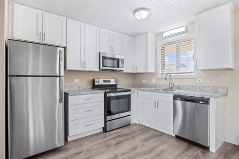 A kitchen with white cabinets and stainless steel appliances.