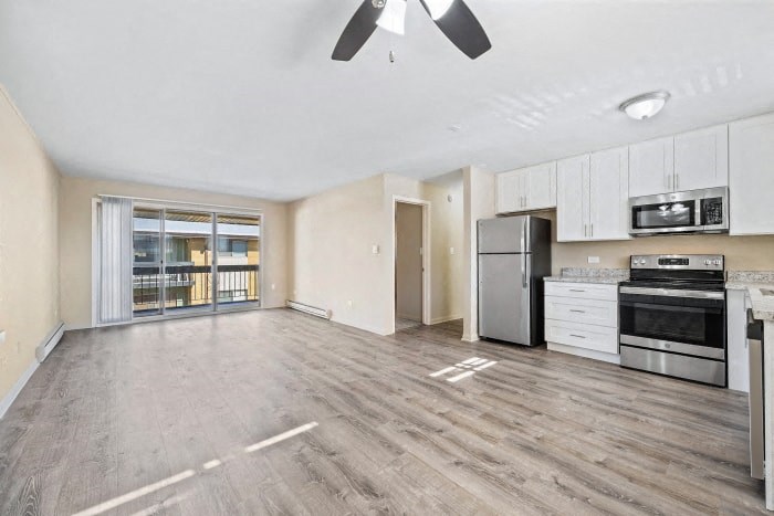 an empty kitchen and living room with a stove and refrigerator