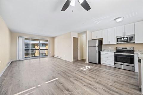 A spacious kitchen with stainless steel appliances and a ceiling fan.