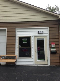 A small building with a bench outside.