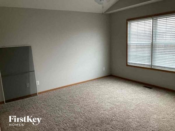 an empty room with a window and a dresser