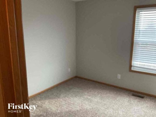 a bedroom with a window and a carpeted floor