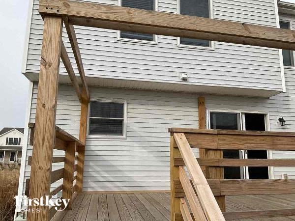 a white house with a wooden deck in front of it