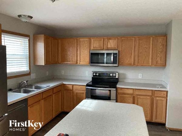 a kitchen with a stove and a sink and a microwave