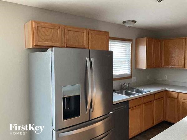 a kitchen with a stainless steel refrigerator and wooden cabinets
