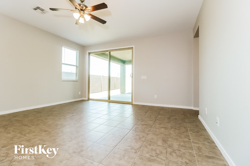 A spacious room with a ceiling fan and sliding glass doors.