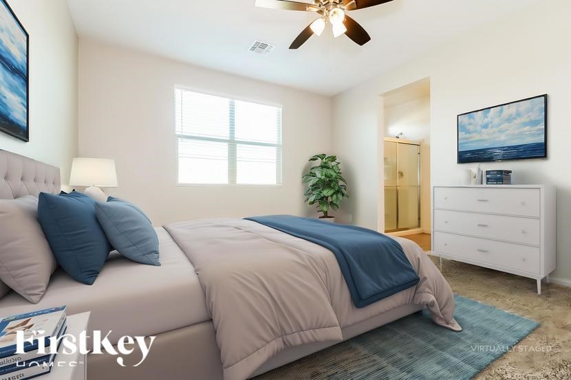 A bedroom with a bed, dresser, and ceiling fan.