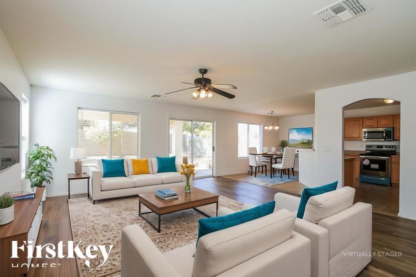 A living room with a white couch and a wooden coffee table.
