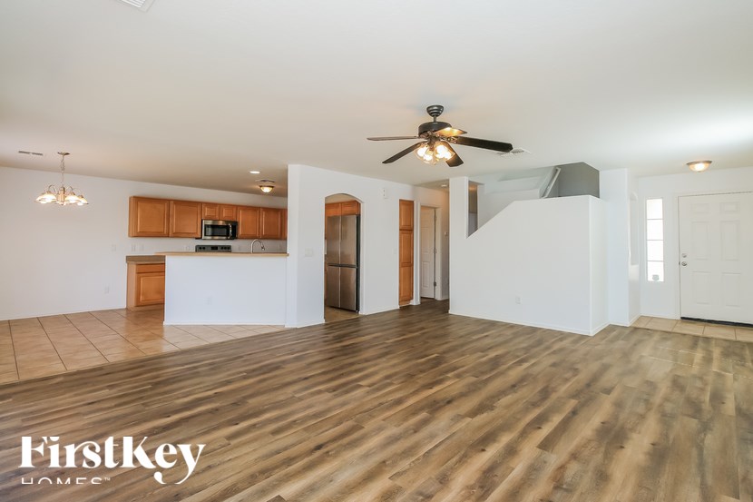 A spacious room with wooden floors and a ceiling fan.