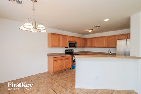 A kitchen with wooden cabinets and a tile floor.