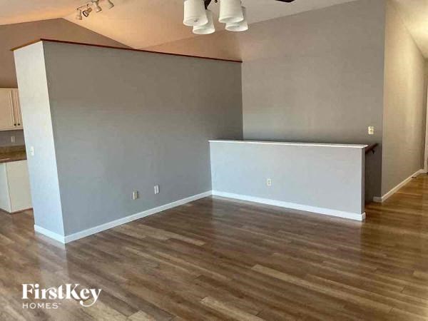 A room with wooden flooring and a white wall.