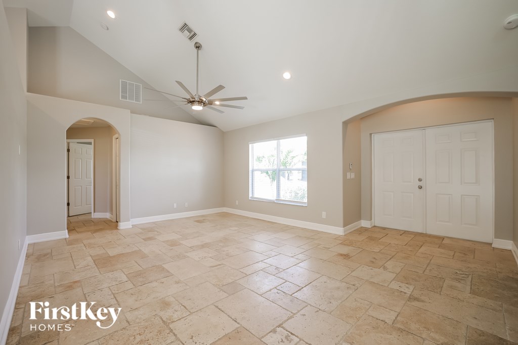 A spacious room with a fan and tiled flooring.