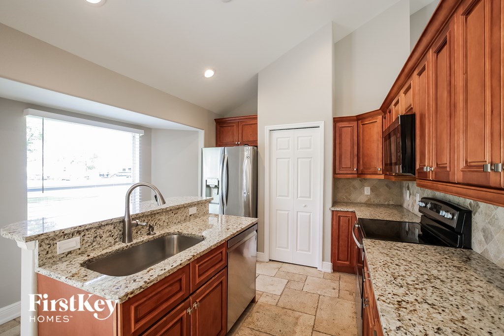 A kitchen with granite countertops and wooden cabinets.