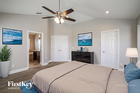 A bedroom with a large bed and a ceiling fan.