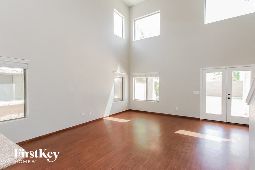 an empty living room with wood floors and white walls