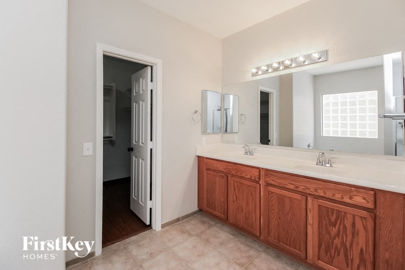 a bathroom with a sink and a mirror and a door to a closet