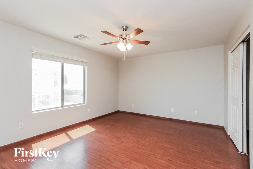 a living room with wood flooring and a ceiling fan