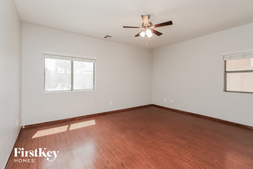 a living room with wood flooring and a ceiling fan