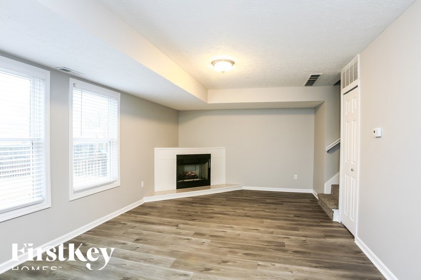 A room with a fireplace and wooden floors.