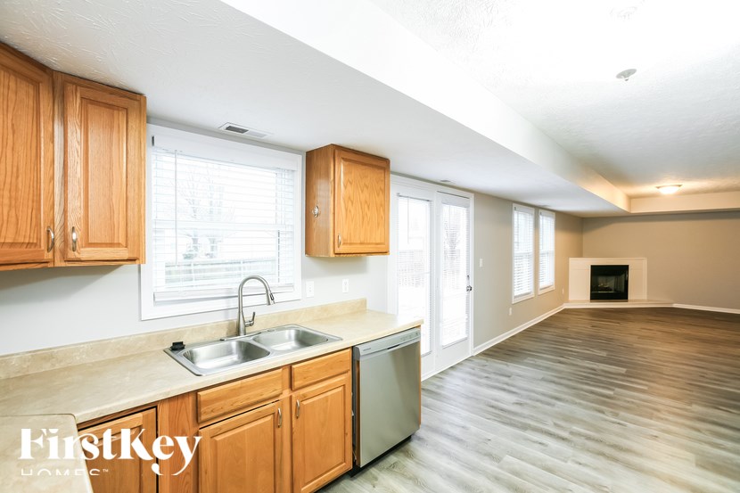 A kitchen with wooden cabinets and a white sink.