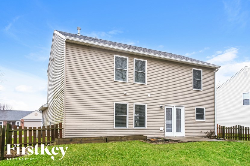 A house with a brown siding and a white door is for sale.