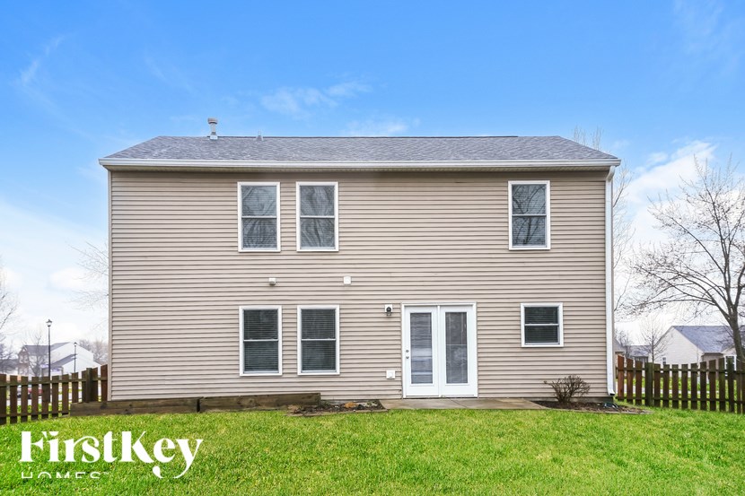 A two-story house with a grey facade and a white door.