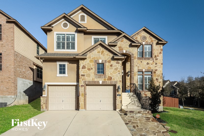 a tan brick house with two garage doors