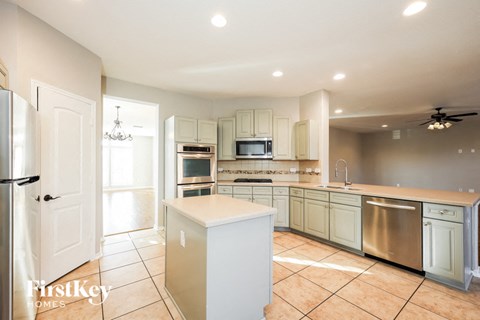 a large kitchen with white cabinets and stainless steel appliances
