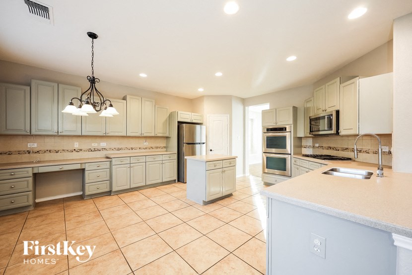 a large kitchen with white cabinets and stainless steel appliances