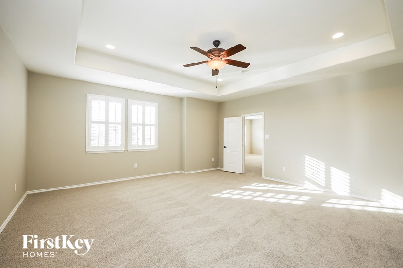 an empty living room with a ceiling fan