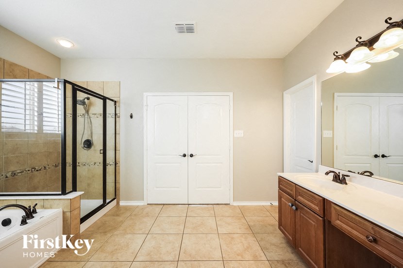 a bathroom with a shower and a sink and a mirror
