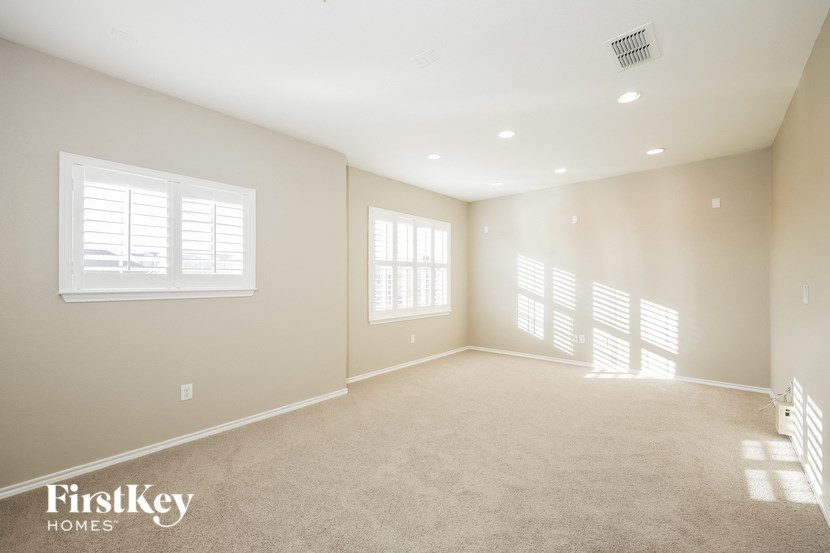 an empty living room with white blinds on the window