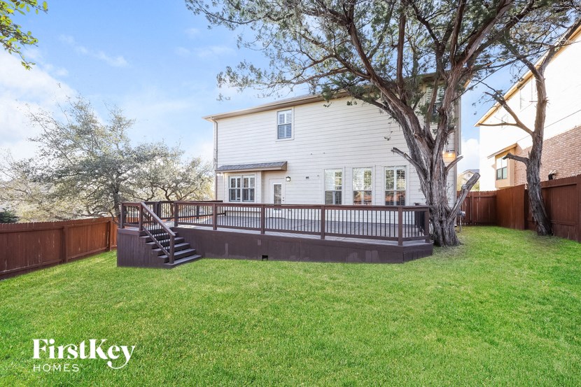 the back of a house with a deck and a fence