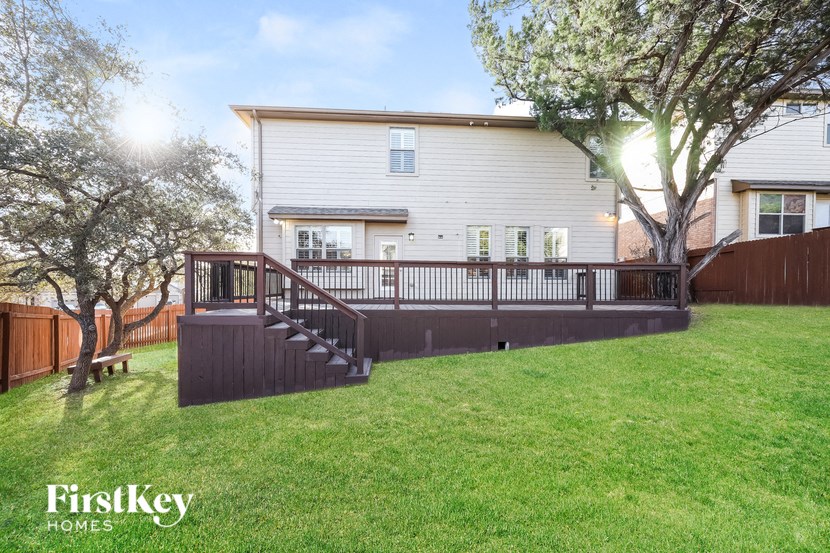 a backyard with a deck and a house