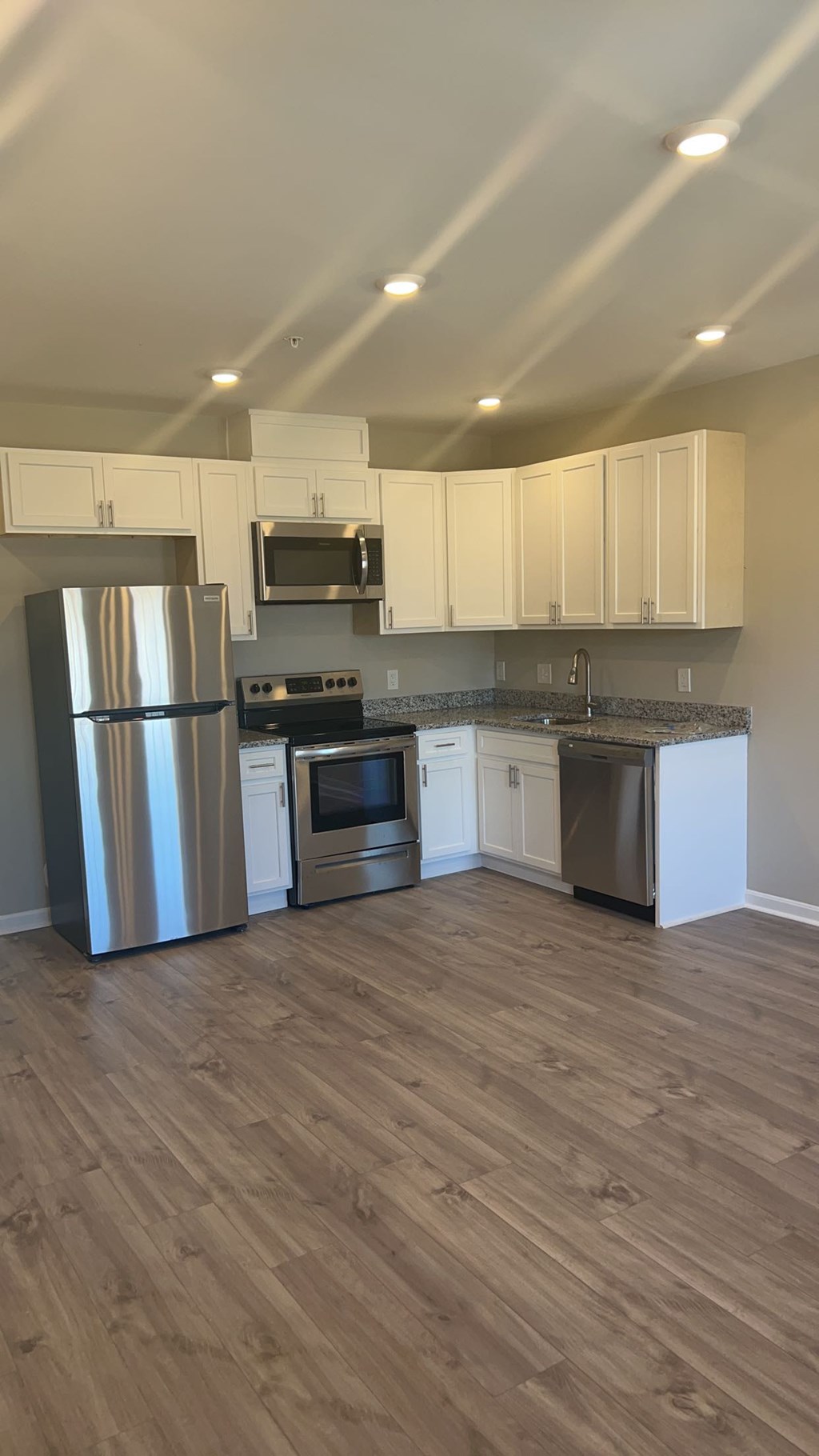 A kitchen with wooden floors and stainless steel appliances.