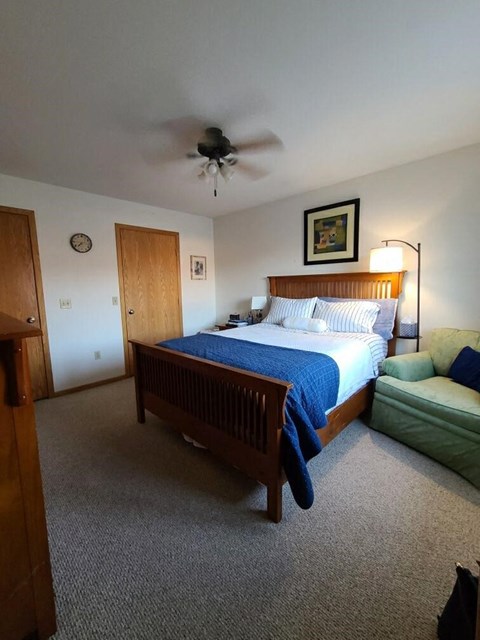 a bedroom with a bed and a ceiling fan