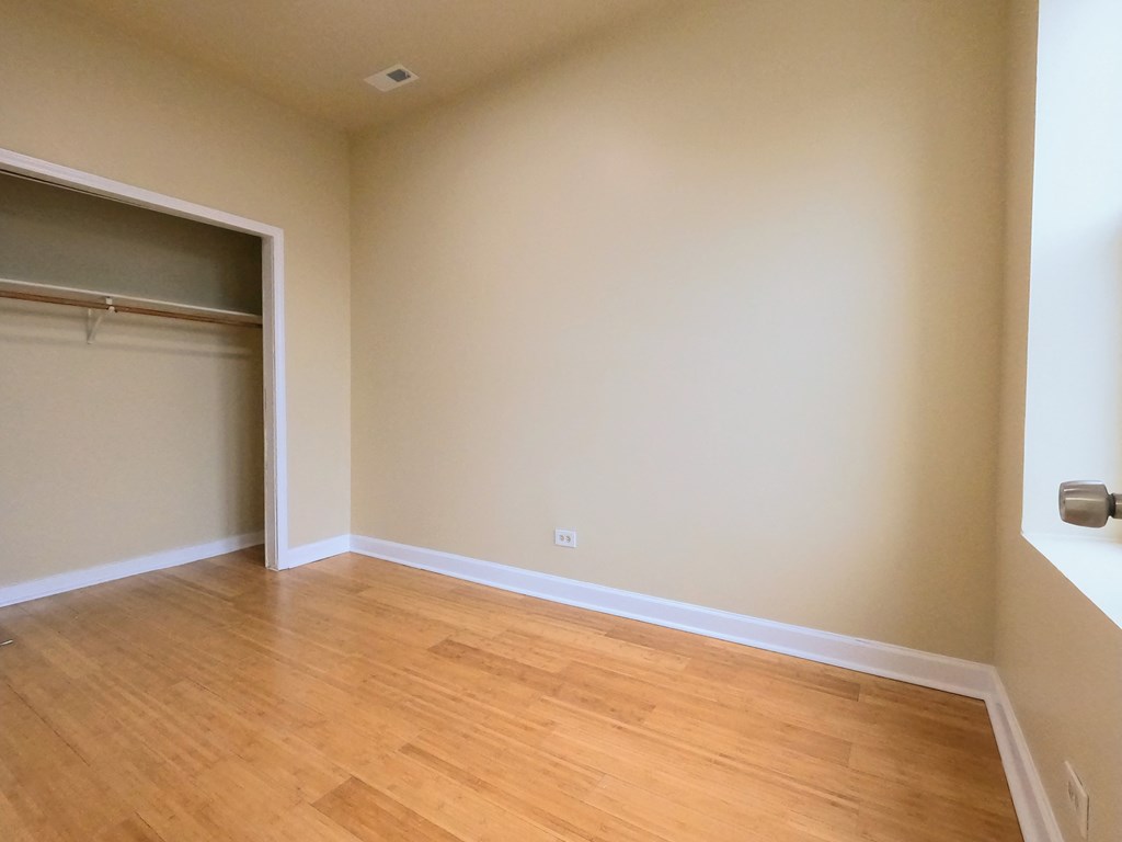 an empty room with wooden floors and a closet