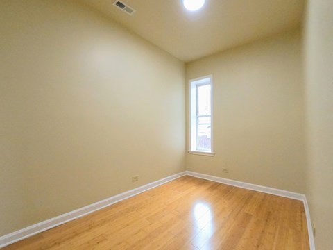 an empty room with wooden floors and a window