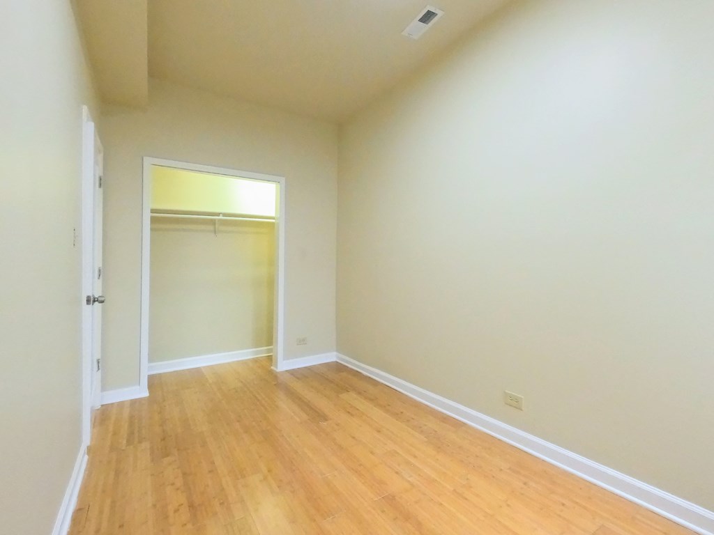 an empty room with wooden floors and a closet
