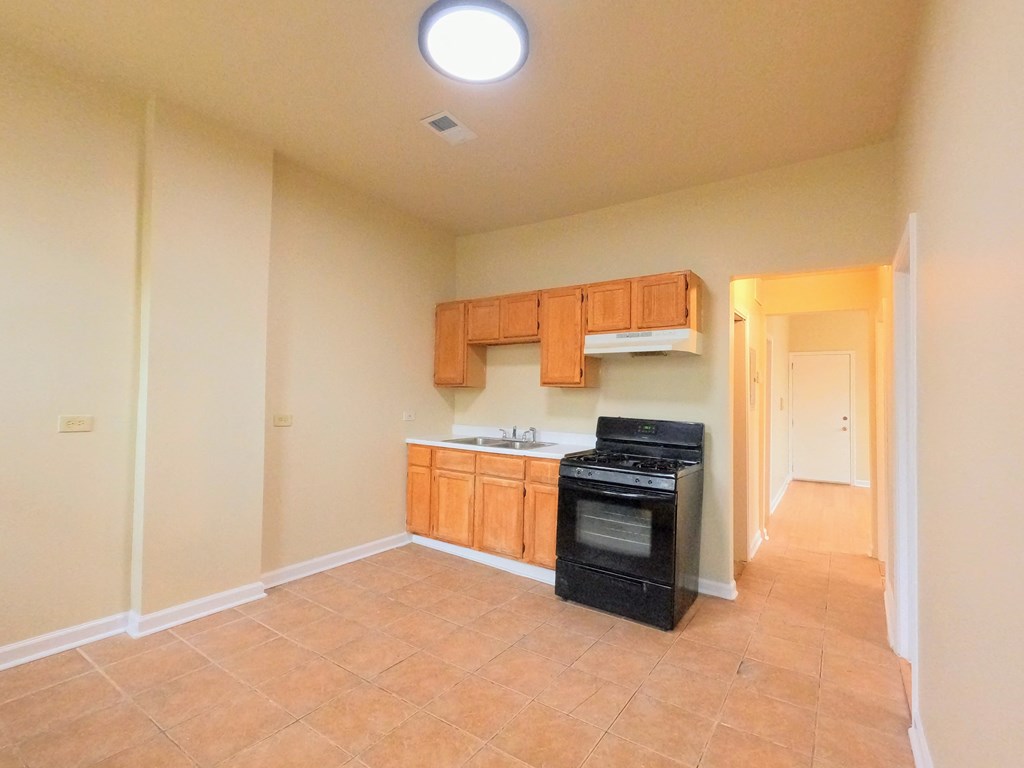 an empty kitchen with a stove and a sink