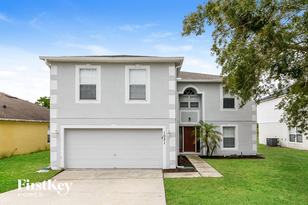 A two-story house with a garage is for sale.